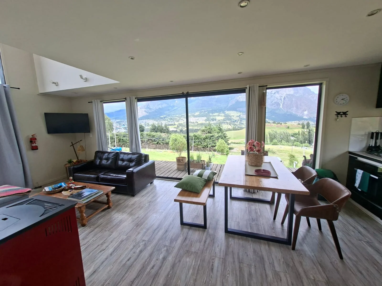 Living, comedor y cocina integrados frente a grandes ventanales con vista a las montañas
