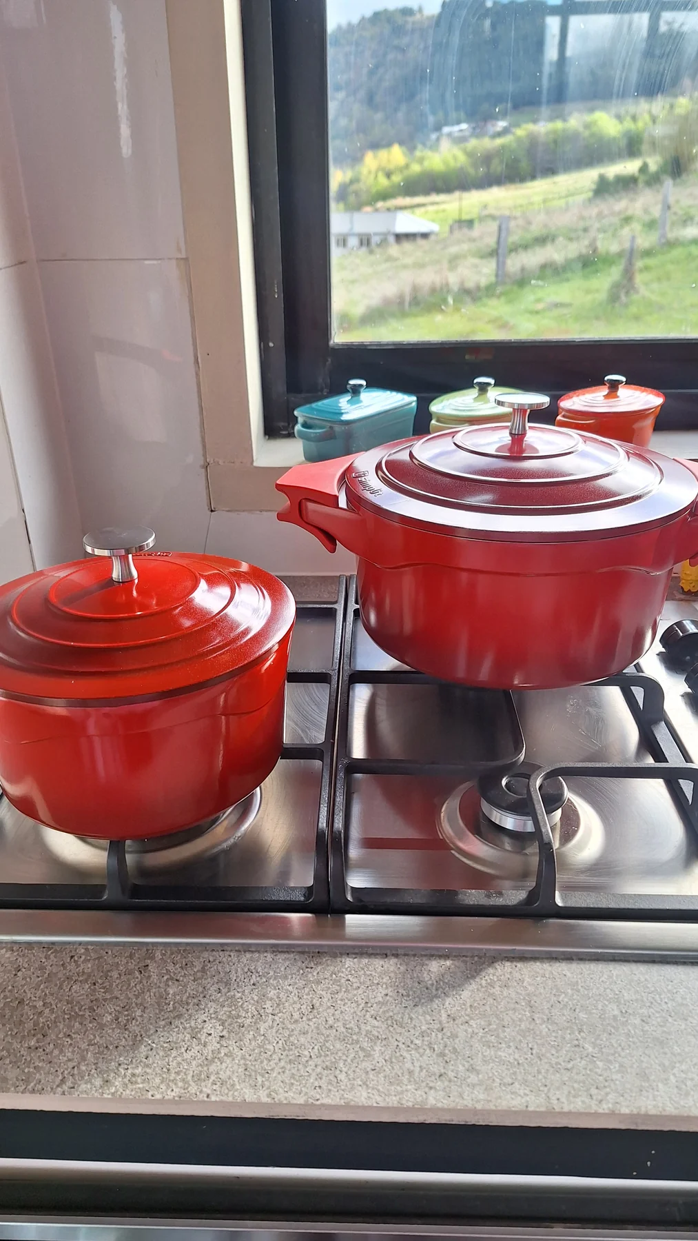 Ollas y sartenes rojos sobre la cocina de Casa Lavanda