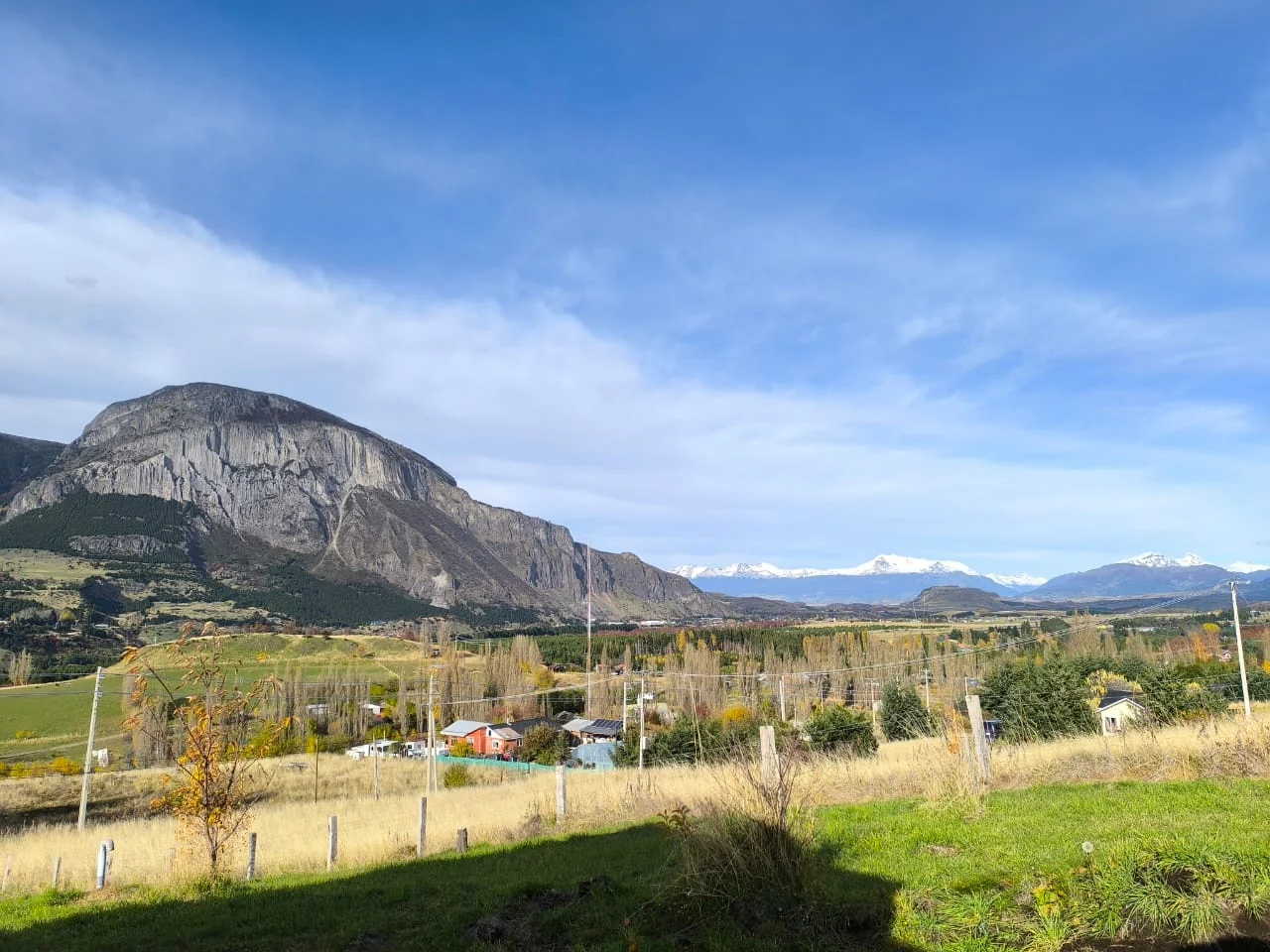 Cerro rocoso y valle de Coyhaique bajo un cielo azul con nubes